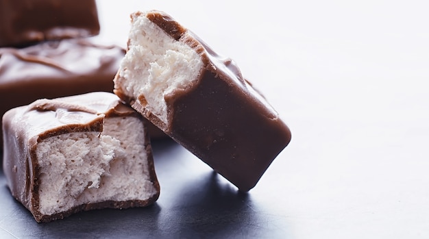 Barras de chocolate sobre un fondo negro a contraluz. Chocolate con relleno. Dulces dulces para merienda y té.