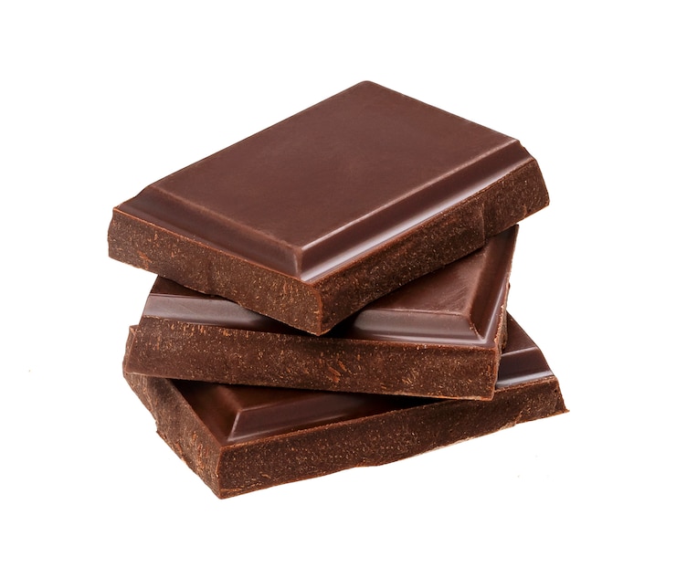 Barras de chocolate escuras isoladas no fundo branco. Pilha de pedaços de chocolate, closeup