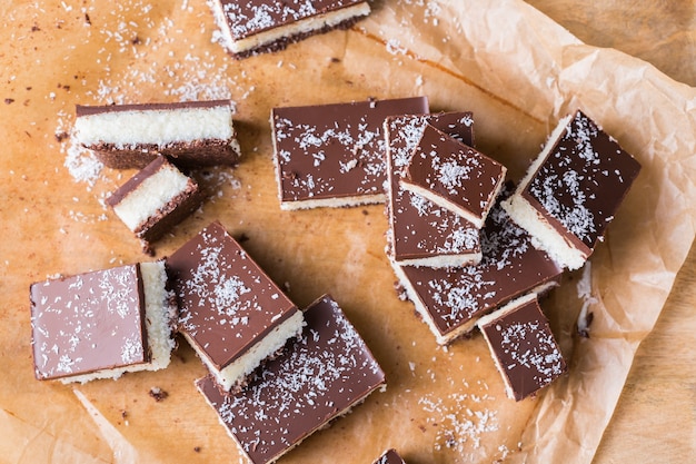 Barras de coco vegano cru orgânico e orgânico de energia saudável caseiro com chocolate na mesa da cozinha