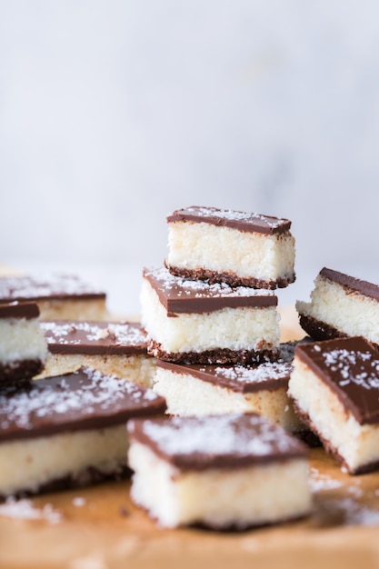 Barras de coco vegano cru orgânico e orgânico de energia saudável caseiro com chocolate na mesa da cozinha