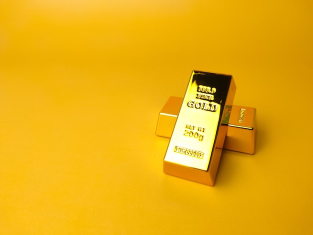 Barras de ouro e conceito financeiro e imagem conceitual em um fundo amarelo com espaço de cópia e texto