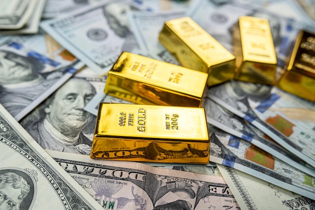 Barras de ouro sobre o conceito de economia de investimento em notas de dinheiro em dólar