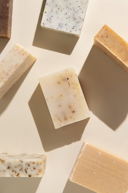 Barras de sabão artesanais naturais de ervas beige e marrom em sombras duras de vista de cima beige Produtos de higiene