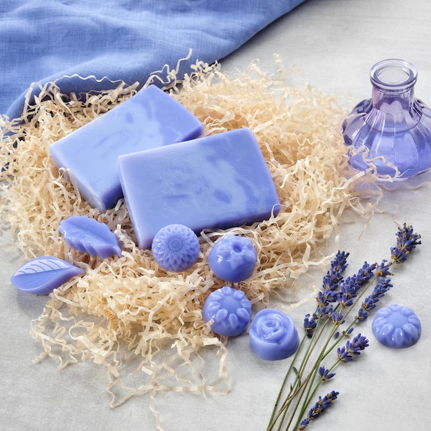 Foto barras de jabón de lavanda caseras y botella de extracto de lavanda de jabón en forma de caramelo y flores secas de lavanda