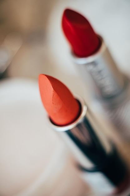 Barras de labios naranjas y rojas macro de herramientas de maquillaje real de primer plano