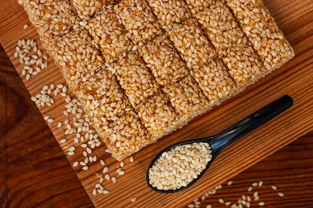 Barras de miel con semillas de sésamo closeup sobre fondo de madera Dulces Gozinaki Espacio de copia de confección oriental tradicional