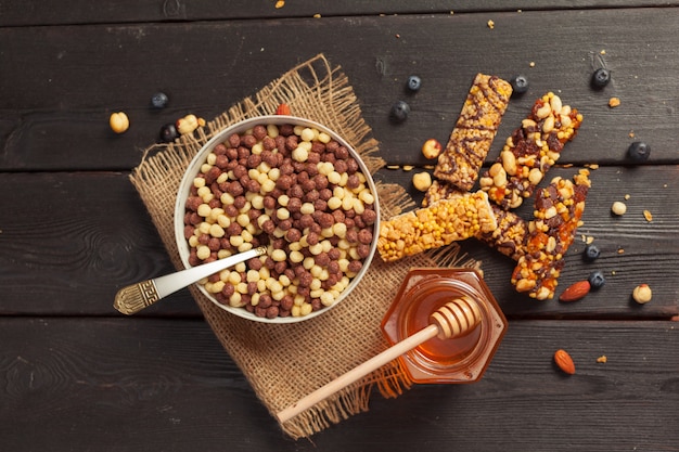 Barras saludables con nueces, semillas y frutas secas en la mesa de madera