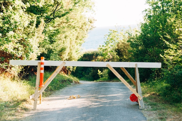 Barrera a la entrada del bosque en medio de la carretera