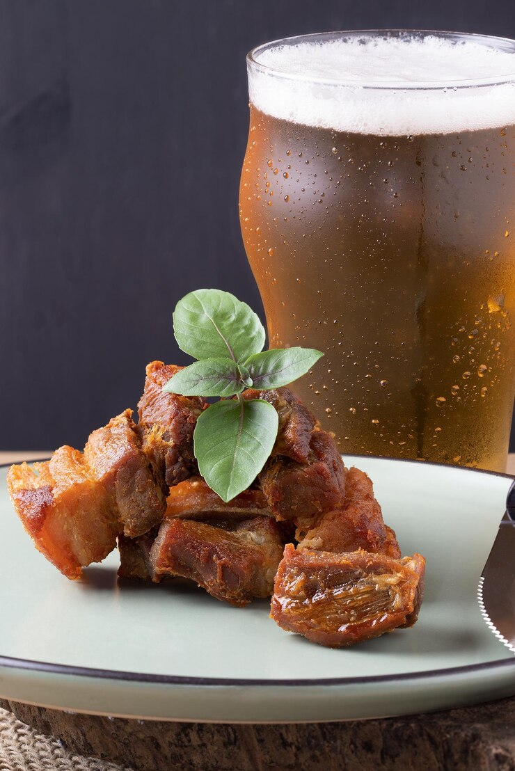 Foto barriga de carne de porco servida com cerveja.