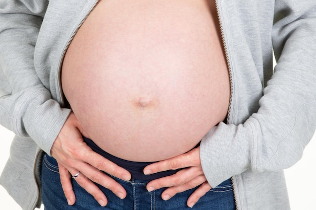 Barriga grávida de mulher em colete aberto