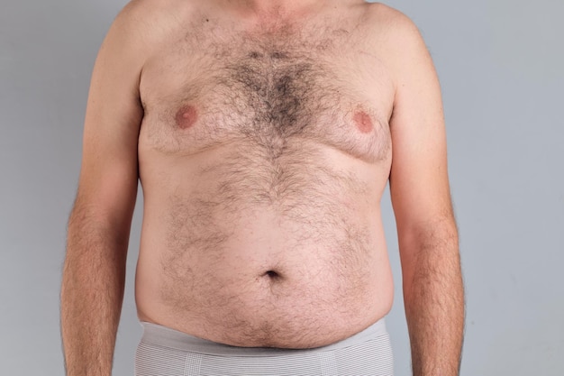 Barriga peluda gorda de um homem caucasiano isolado em fundo cinza sem rostos são mostrados