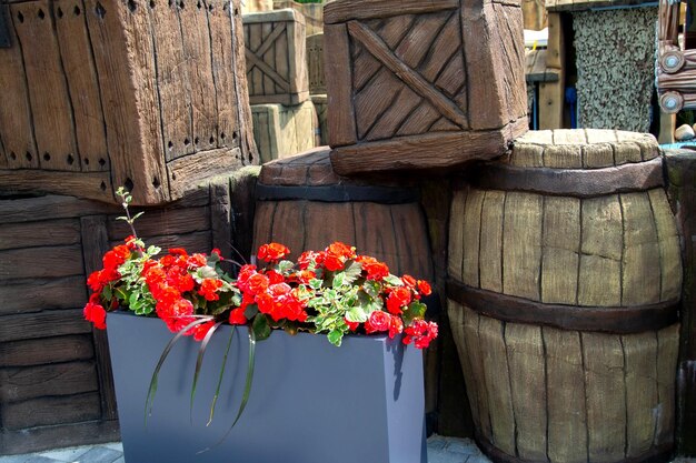 Un barril de madera con flores rojas en él