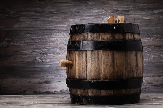 Barril de madera vieja de pie sobre la mesa en la antigua bodega