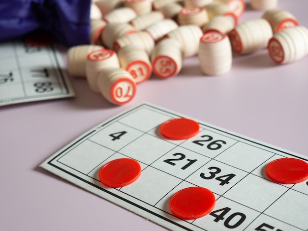 Foto barriles de madera de lotería, naipes para jugar a la lotería con una bolsa en un lila pálido