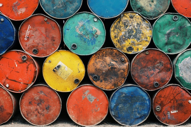 Barriles metálicos oxidados y coloridos apilados en un disparo de fotograma completo