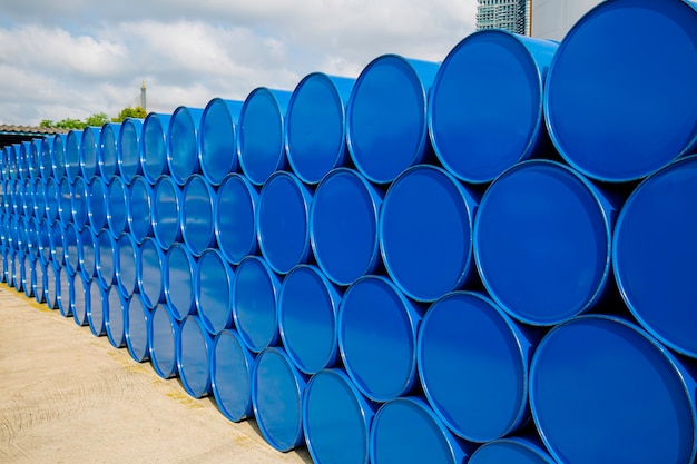 Barriles de petróleo azul o tambores químicos apilados horizontalmente