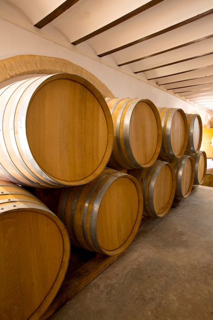 barriles de roble de madera de vino apilados en una fila en bodega