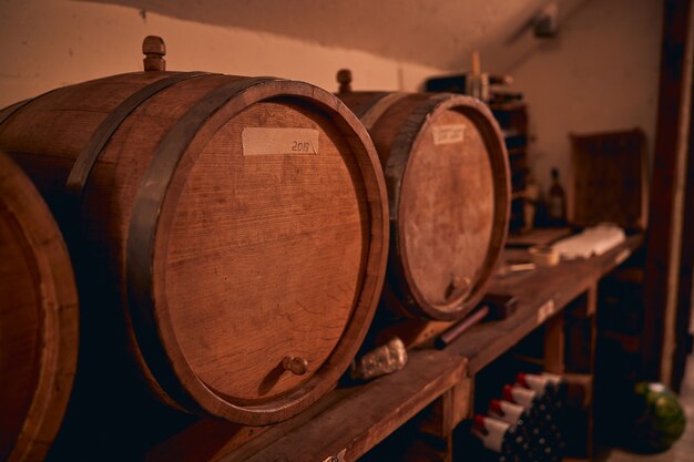 Barriles de vino de madera o toneles con etiqueta de papel de año en bodega