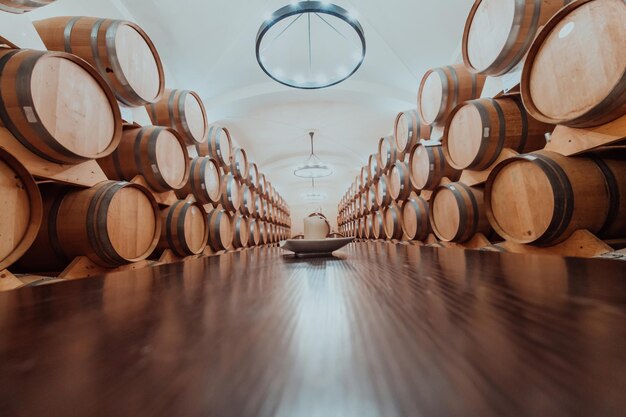 Barriles de vino o coñac en la bodega de la bodega, Barriles de vino de madera en perspectiva. Bodegas de vino. Barriles de roble antiguos de cerveza artesanal o brandy.