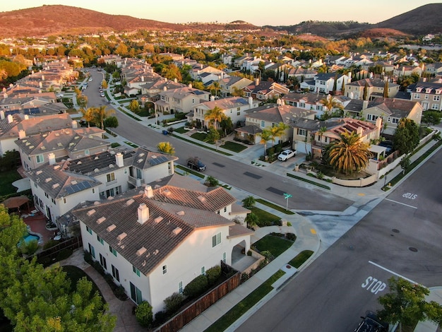 Barrio residencial moderno de casas subdivididas con montaña al fondo durante la puesta de sol