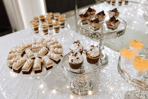 Foto barrita de caramelo para una boda barrita de candy de pie mesa festiva con postres pasteles y macarrones hermosos y sabrosos