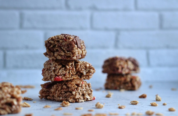 Barritas de cereales en forma de pirámide con granola sobre un fondo gris