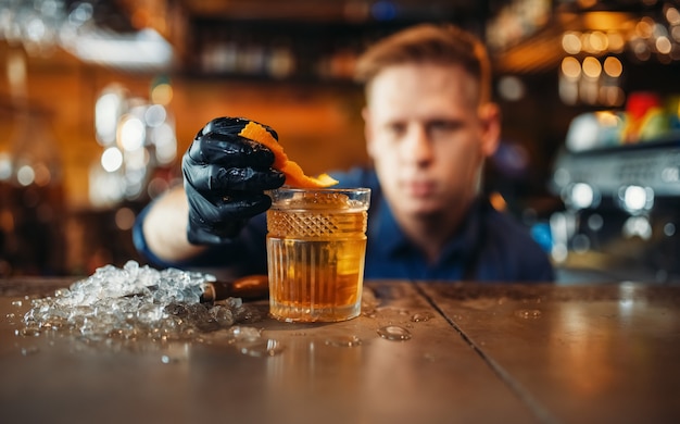 Bartender agrega piel de naranja a bebidas alcohólicas