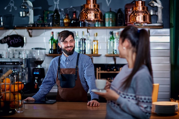 Bartender, barista y cliente en el café bar restaurante.