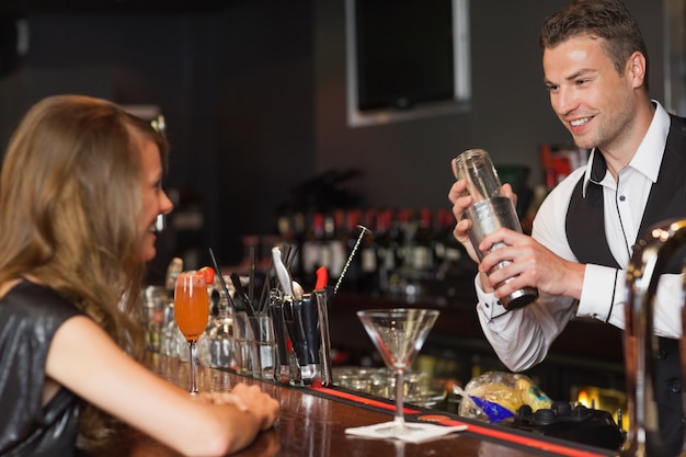 Bartender bonito que serve coquetel para mulher bonita