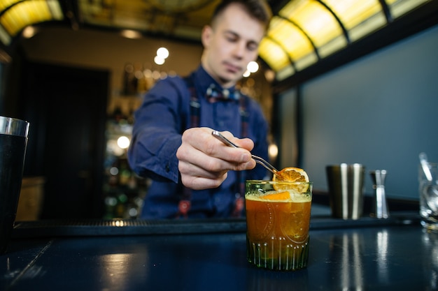 Bartender está haciendo un cóctel en el bar.