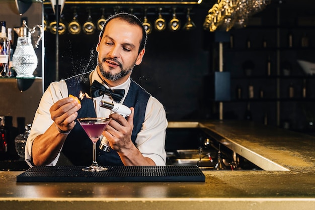 Bartender haciendo bebidas en el mostrador en el bar