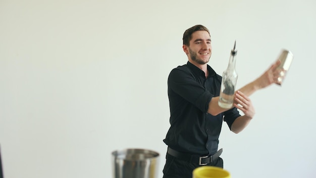 Bartender profesional hombre haciendo malabares con botellas y agitando cócteles