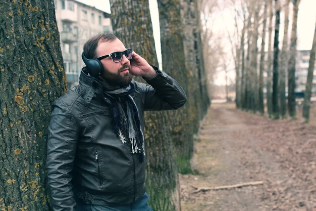 Bartmann im Park mit Kopfhörer