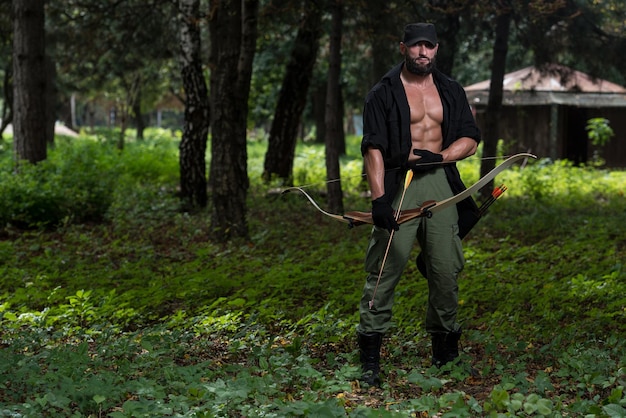 Bartmann mit Pfeil und Bogen im Wald