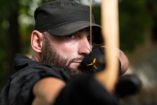 Foto bartmann mit pfeil und bogen im wald