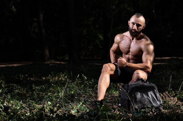 Bartmann ruht sich draußen im Park vom Fitnessstudio aus