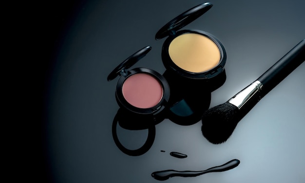 Base de polvo de rubor en polvo y pincel de maquillaje sobre fondo negro Productos cosméticos Maquillaje