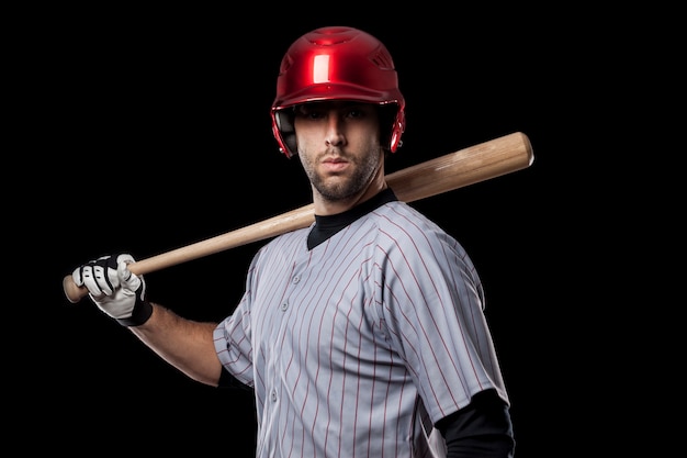 Baseballspieler auf einem schwarzen Hintergrund. Studioaufnahme.