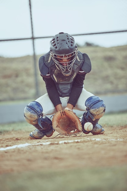 Baseballsport und Ball mit einem Fänger auf einem Rasen oder Feld während eines Spiels oder Spiels im Freien Fitnessübungen und Fang mit einem männlichen Baseballspieler, der draußen einen Wettkampfsport spielt