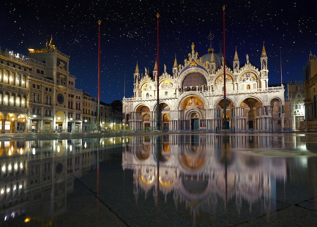 Basílica en la plaza San Marco en Venecia con reflexión sobre la noche de marea alta