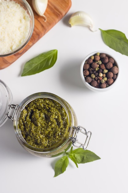 Basilikum-Pesto-Sauce in einem Glas Zutaten zum Kochen von Käse Parmesan-Knoblauch-Olivenöl