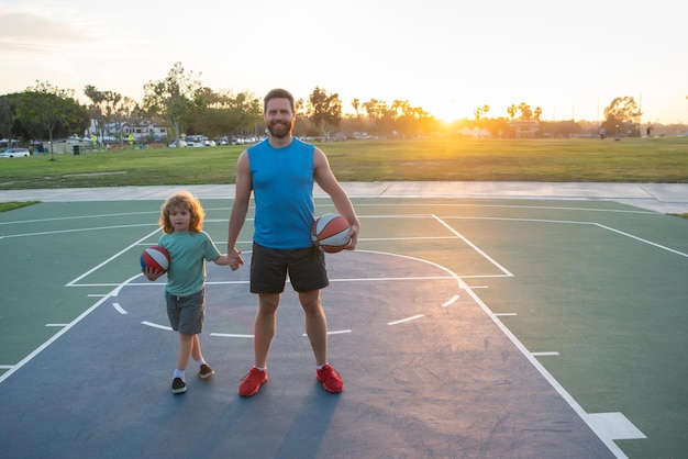 Basketball Spiel. Vater und Sohn trainieren mit Basketball auf dem Basketballplatz im Freien. Papa und Kind verbringen Zeit zusammen.