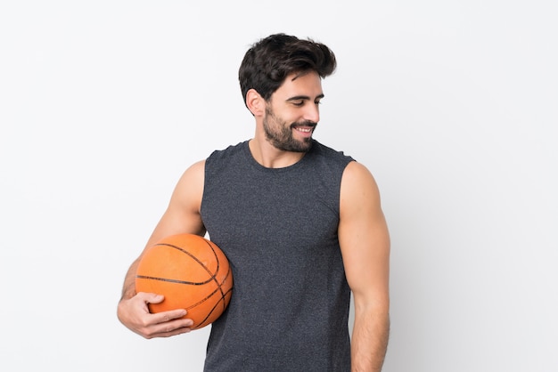 Basketball-Spielermann mit Bart über der lokalisierten weißen Wand, die Seite schaut