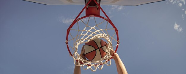 Basketballball Dunk durch Netzring mit gewinnenden Händen