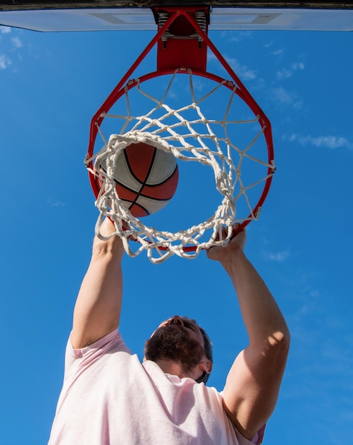 Basketballspieler wirft den Ball in den Basketballkorb im Freien