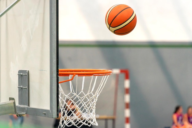 Basquete no ar prestes a entrar no aro da tabela.