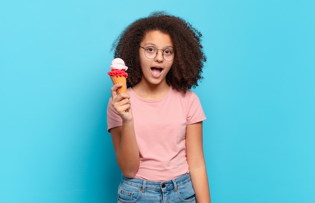 Bastante adolescente afro que parece muy conmocionado o sorprendido, mirando con la boca abierta diciendo wow. concepto de helado sumer