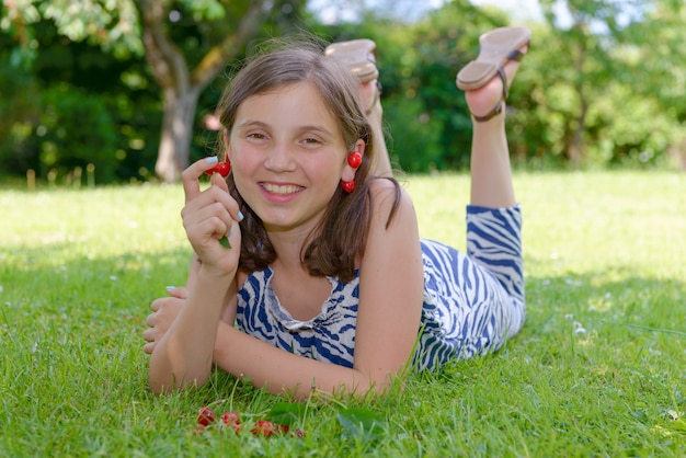 Bastante adolescente al aire libre con cerezas