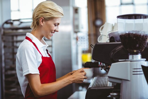 Bastante barista usando la máquina de café