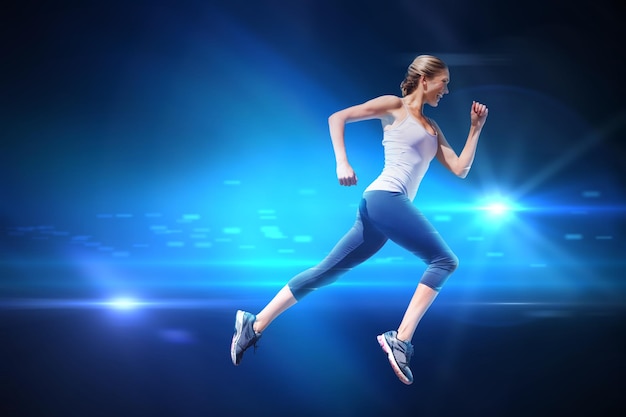 Bastante en forma rubia jogging contra fondo negro con chispa